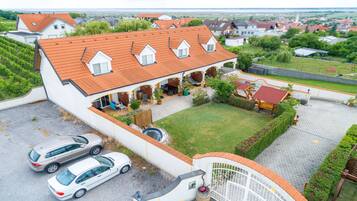 A residential property with a covered patio, a swimming pool, and a garage with two cars.