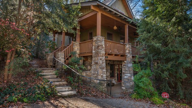 A cabin with a stone foundation, wooden exterior, and a porch with a stone railing. - Mountain Gem I Pet Friendly Luxury Cottage in Cheshire Village (Black Mountain)
