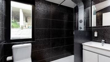 Un baño moderno con inodoro, lavamanos y ducha.