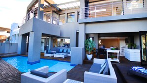 A modern house with a swimming pool, outdoor furniture, and a balcony. - C' la Vie Melkbos (Cape Town)