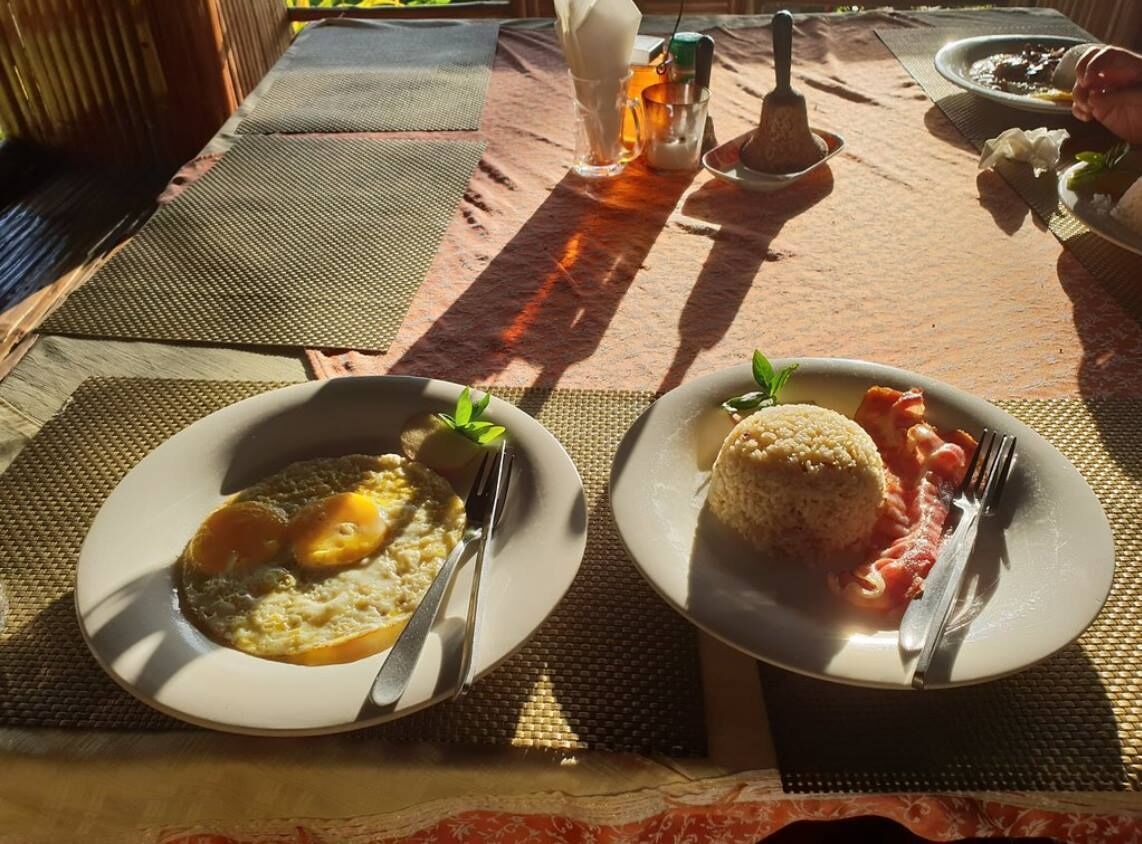 Two plates of food on a table with a woven placemat.
