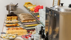 A buffet with various food items and a beverage dispenser. - Hotel Centenário (Tramandai)