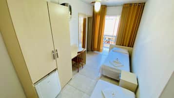 A compact hotel room with a bed, a desk, and a wardrobe.