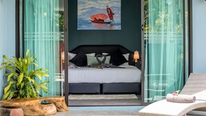 Un dormitorio moderno con una cama, un cuadro y vistas a través de un ventanal.