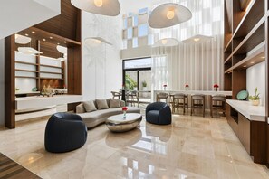 Un interior moderno con sofá modular, una mesa de centro redonda y asientos tipo barra.