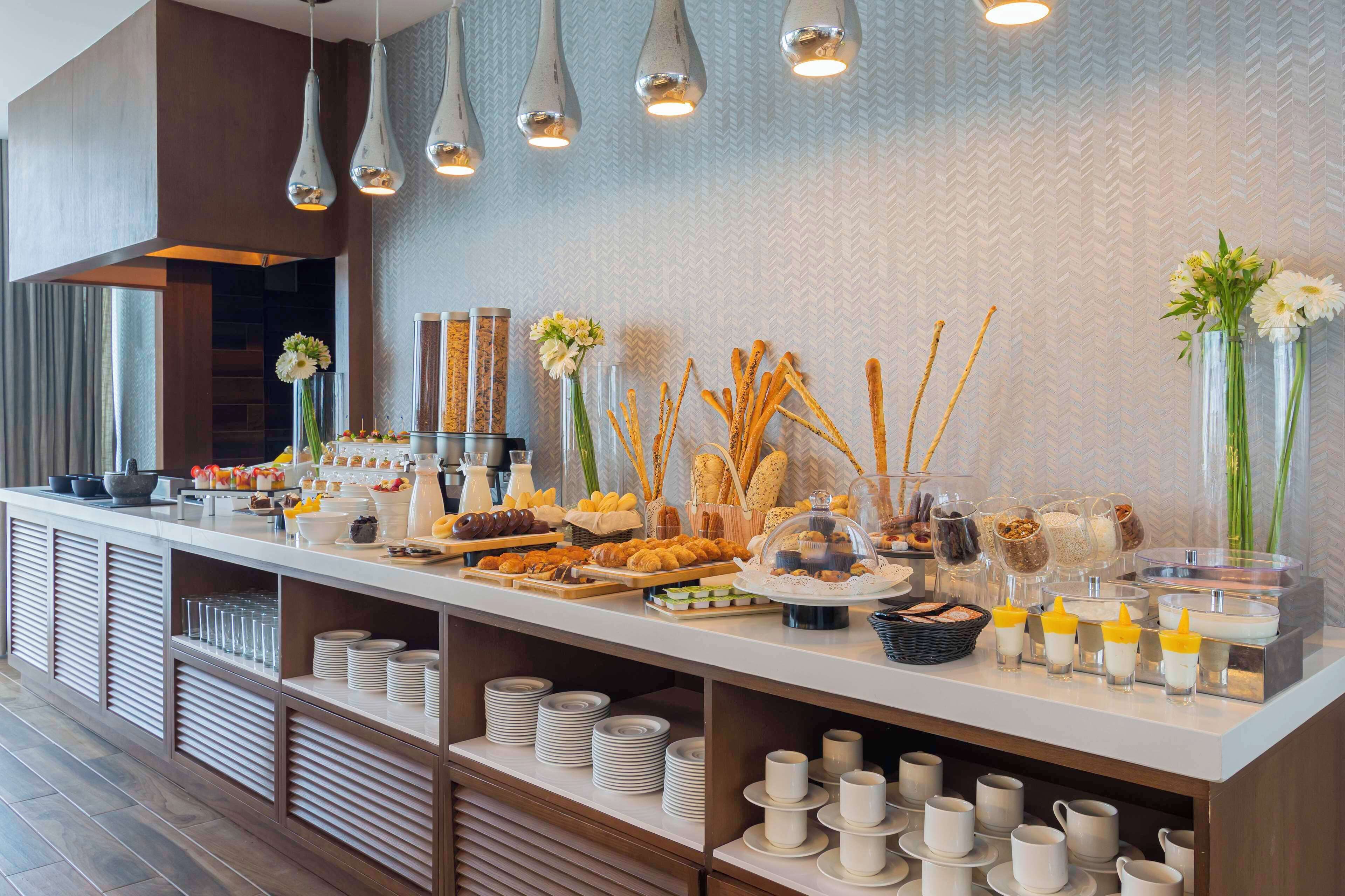 A buffet setup with various food items, glassware, and decorative elements.