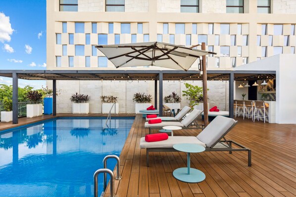 Una piscina al aire libre, sillones reclinables de piscina