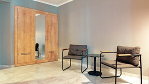 A room with a wooden wardrobe, two armchairs, and a small round table. - Simply Fine Hotel Alize - Adults Only (Alanya)