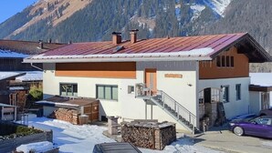 Um edifício moderno com telhado vermelho e escadas que levam à entrada.