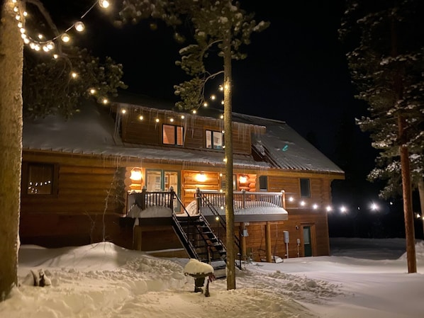 A log cabin with a wooden exterior, a front porch, and a staircase leading to the entrance. - Secluded Custom Log Home w Hot Tub - by Winter Park, Granby Ranch & Grand Lake (Tabernash)