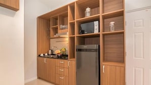 Eine moderne Küche mit Holzschränken, einem Edelstahlkühlschrank und einer Mikrowelle.