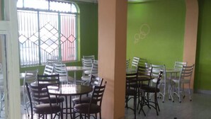 A dining area with tables and chairs, green walls, and a tiled floor. - Mt Kenya Safari Halt Hotel (Chaka)