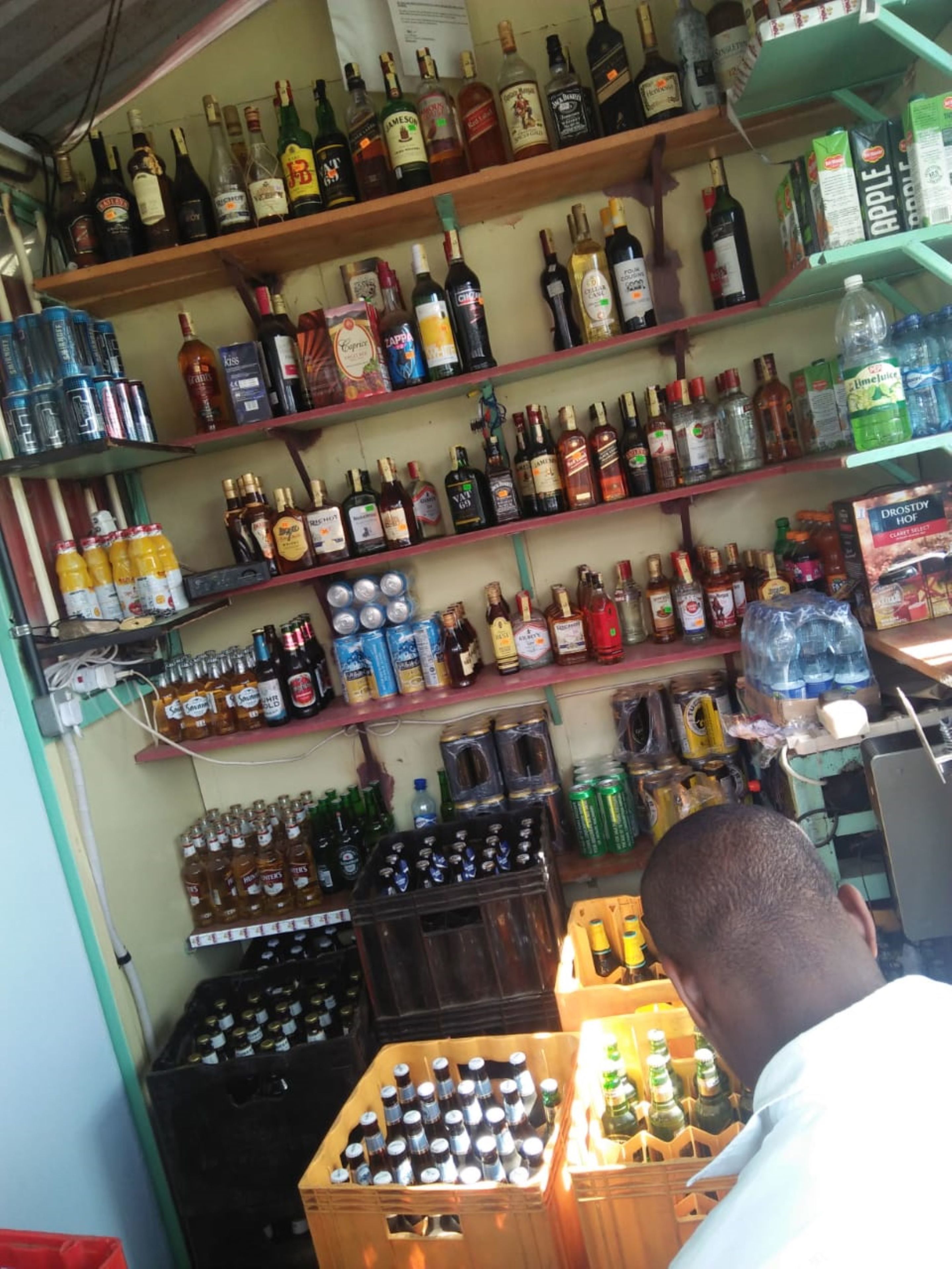 A liquor store with shelves stocked with various bottles and cans.