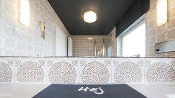 A bathroom with patterned tiles, a black towel, and a mirror.