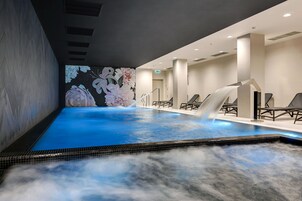 Una piscina techada, sillones reclinables de piscina