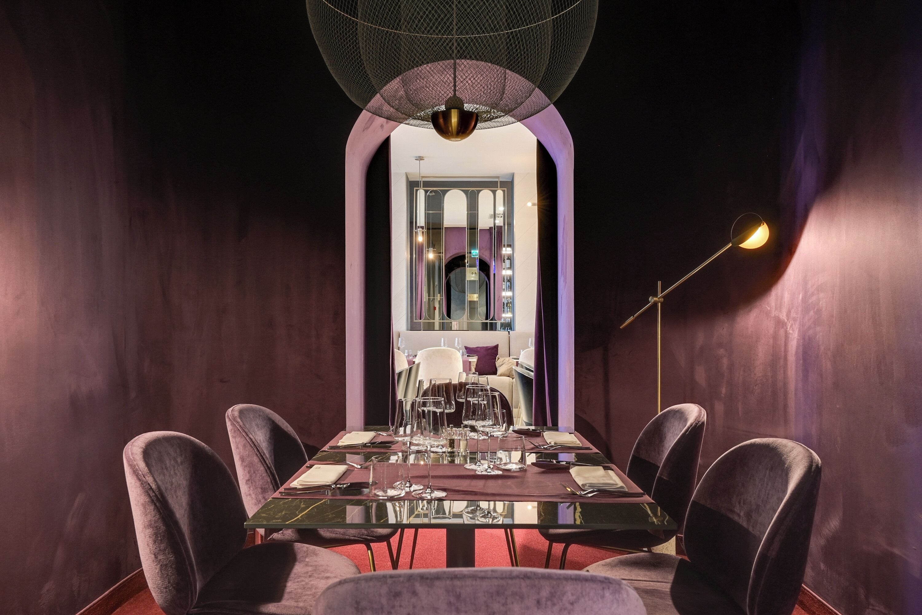 Un espace repas avec une longue table, des chaises et un lustre.