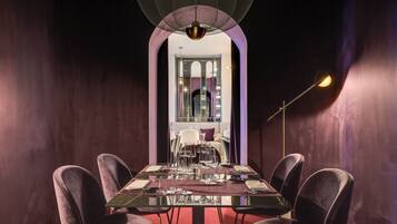 Un espace repas avec une longue table, des chaises et un lustre.