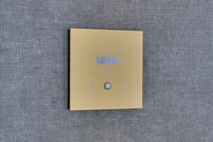 Un termostato con display digitale che indica 21,09 gradi Celsius.
