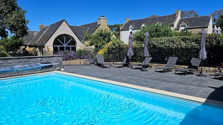 Una piscina al aire libre de temporada, sillones reclinables de piscina. B&B Domaine de Keryargon