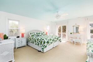 Un dormitorio con cama, escritorio, silla, cómoda y ventilador de techo.