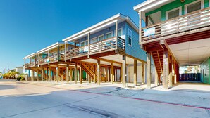 A beachfront property with multiple levels, wooden balconies, and a covered outdoor area. - OV37 Shared Pool, Golf Cart Access (Port Aransas)