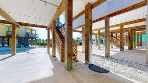 A building under construction with exposed wooden beams, a staircase, and a covered walkway. - OV37 Shared Pool, Golf Cart Access (Port Aransas)