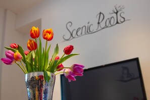 Een vaas met kleurrijke tulpen op een tafel.