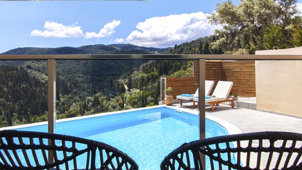 A poolside view with a clear sky, a wooden deck, and a mountain backdrop. - Villa Alba with Private Pool & SeaView (Apolpena)