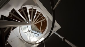 Eine Wendeltreppe mit modernem Design, mit weißen Geländern und Holzstufen.