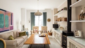 Ein modernes Wohnzimmer mit Couchtisch aus Holz, beigefarbenen Sofas und einem großen abstrakten Gemälde.
