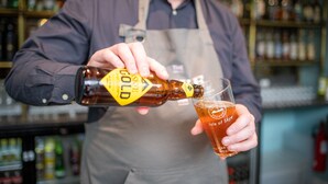 A person pouring a bottle into a glass. - The Skye Inn (Portree)