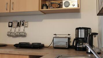Eine Küche mit Holzausstattung, einer Kaffeemaschine, einem Toaster und einem Wasserkocher.