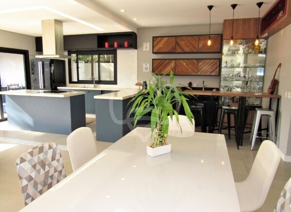 Enjoy cooking and dining in this well-equipped kitchen with a central island, sink, and stainless steel refrigerator.