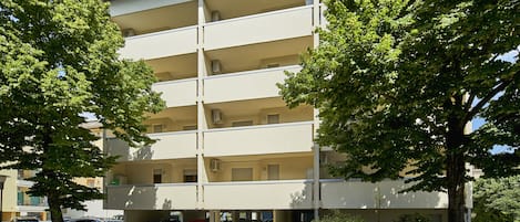 A multi-story apartment building with a parking area in front.