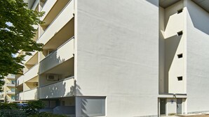 A multi-story building with a flat roof and a parking area in front. - Residence Columbia (San Michele al Tagliamento)