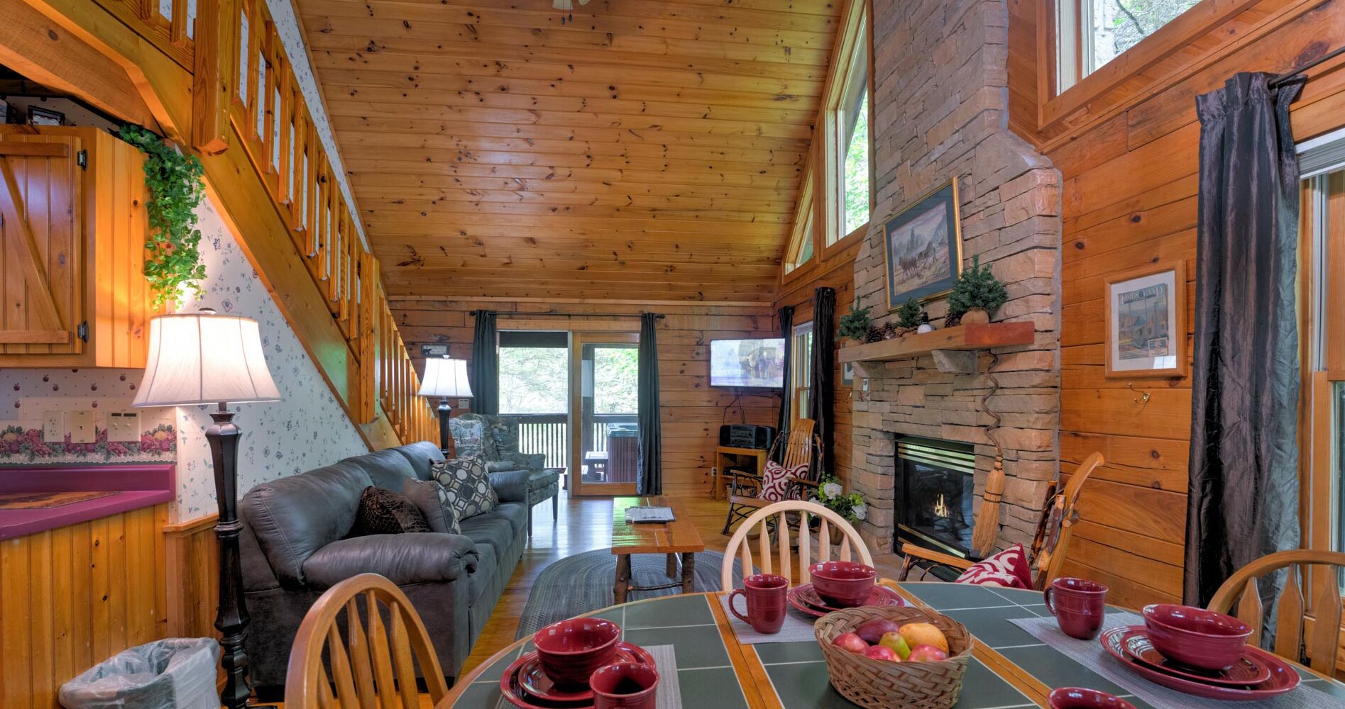 L’intérieur chaleureux d’un chalet avec une table à manger en bois, disposée pour quatre personnes, un canapé en cuir et une cheminée.
