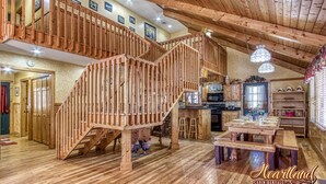 A cabin with a wooden staircase, a dining area, and a kitchen. - Diamond In The Rough, is a terrific family or group cabin. Pigeon Forge Cabin (Sevierville)