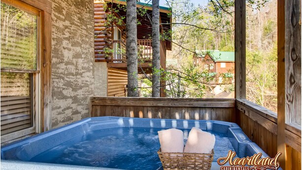A wooden cabin with a hot tub and a basket of towels.