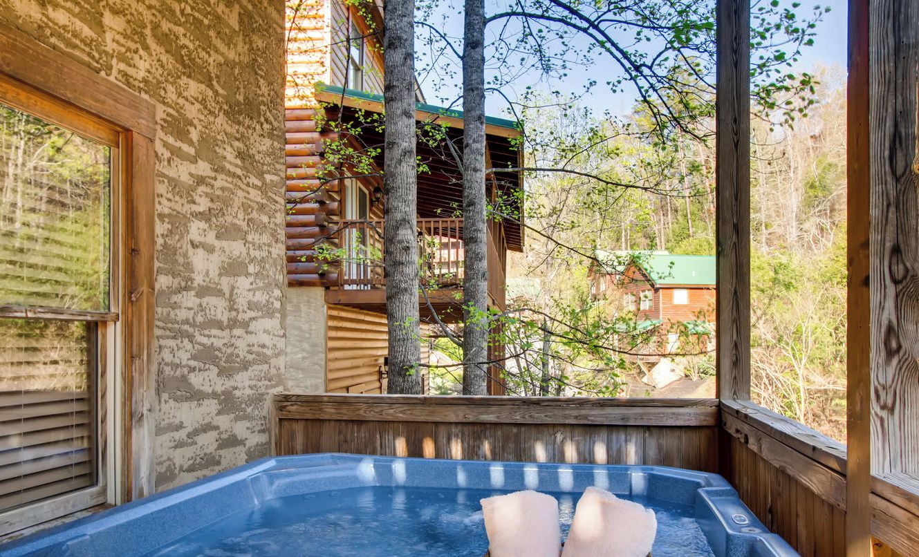 A wooden cabin with a hot tub and a basket of towels.