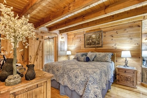 Une chambre à coucher en bois, avec un lit, des tables de chevet et un vase de fleurs.
