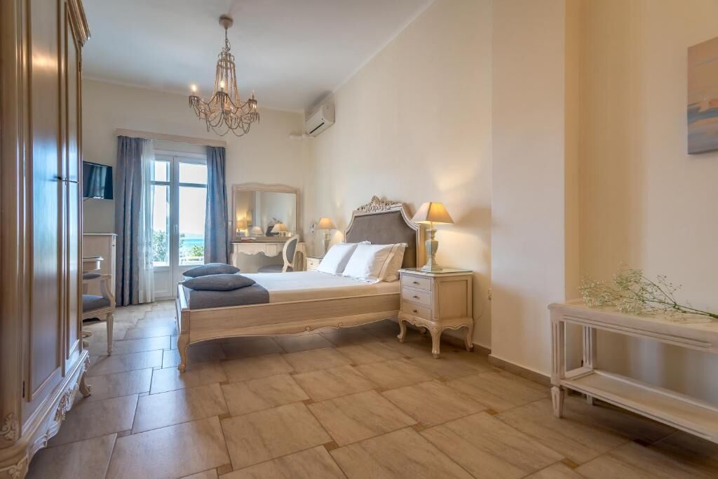 Ein Schlafzimmer mit einem Bett, Nachttischen, einem Schminktisch, einem Spiegel, einer Deckenleuchte und einem Fenster mit Vorhängen.