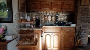 Eine Küche mit Holzausstattung, gefliestem Fliesenspiegel und einer Kaffeemaschine.