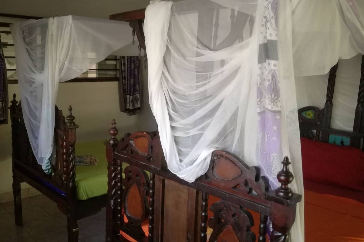Un lit à baldaquin avec un couvre-lit vert et un ciel de lit blanc.