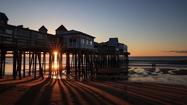 A pier with buildings at the end, leading to the beach. - Cozy home, quiet neighborhood, near OOB attractions! (Old Orchard Beach)