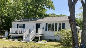 A single-story mobile home with a front porch, a small staircase, and a bicycle parked nearby. - Cozy home, quiet neighborhood, near OOB attractions! (Old Orchard Beach)