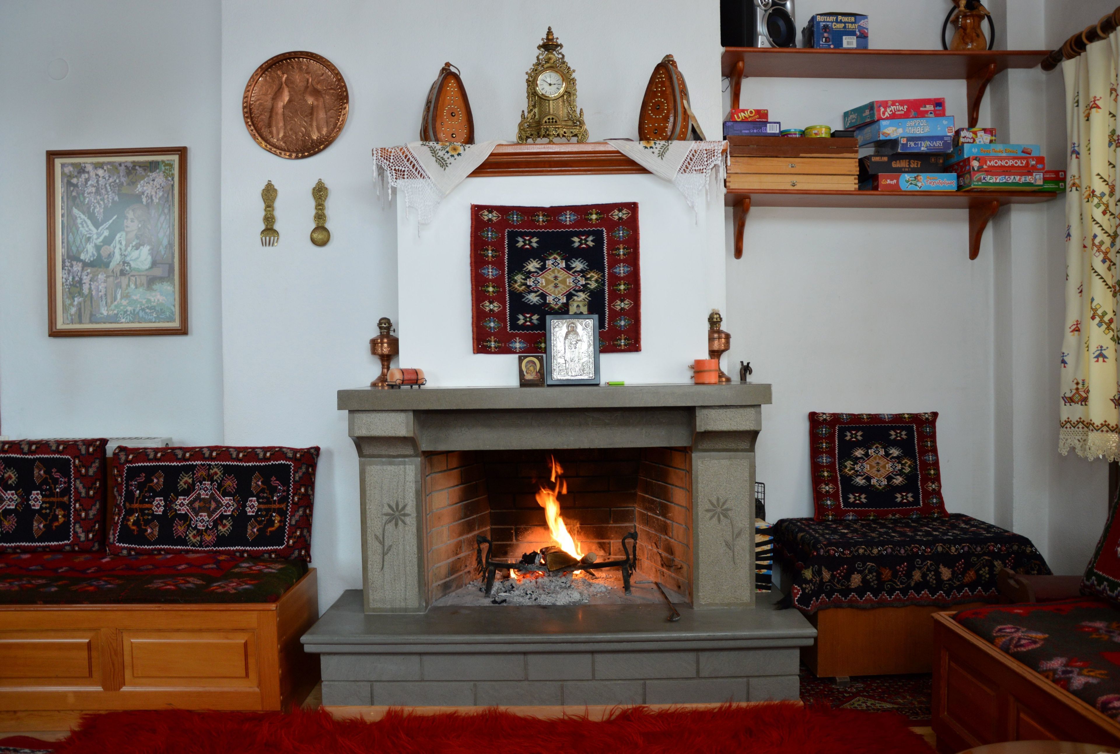 A cozy living room with a fireplace, a bookshelf, and a framed picture on the wall.