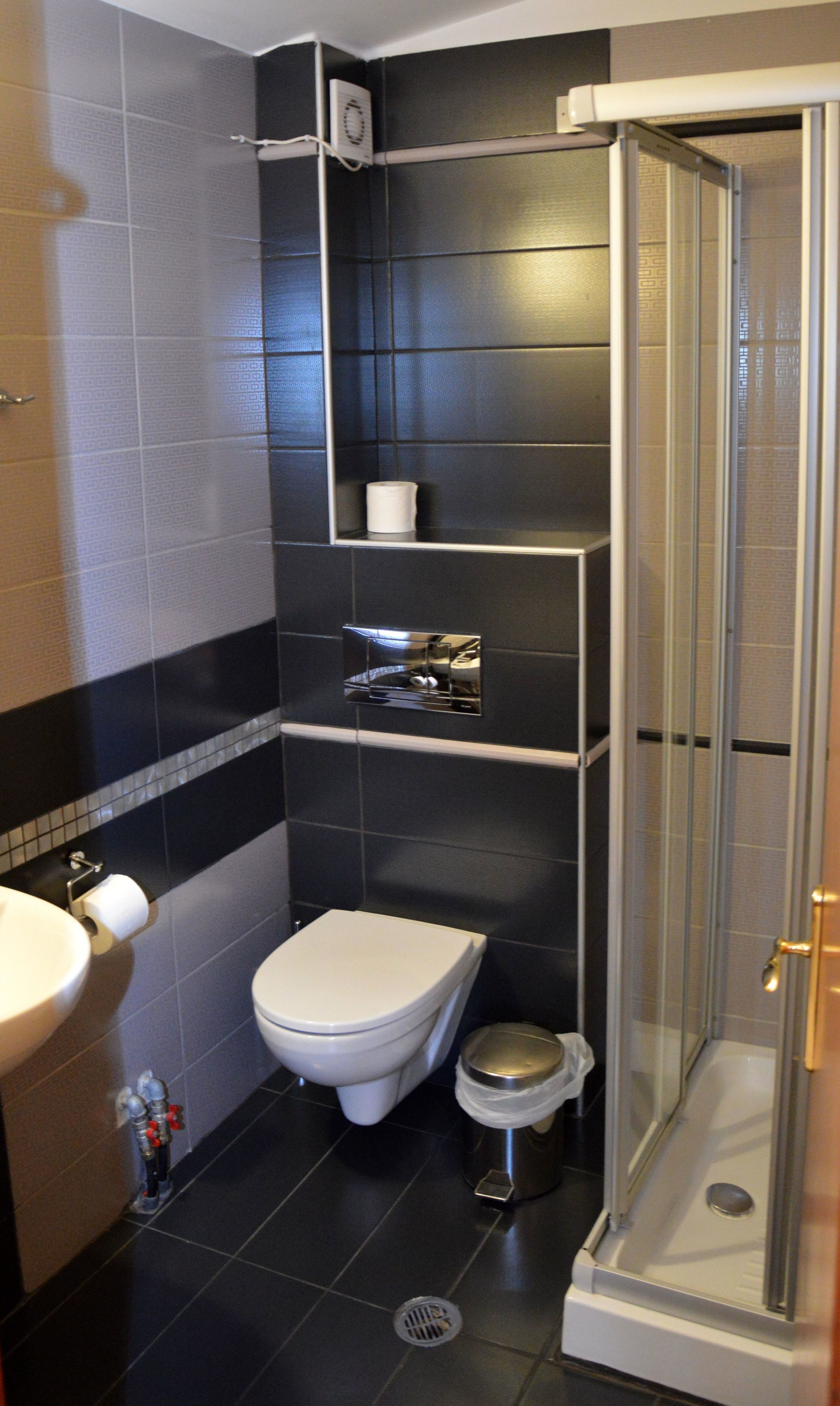 Een moderne badkamer met toilet, wastafel en douche.