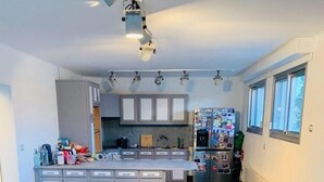 Una cocina moderna con una isla central, una mesa de comedor con sillas y un refrigerador.