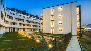 A modern building with multiple floors, a flat roof, and a well-lit exterior. - Lunas Appartements in Essen (Essen)