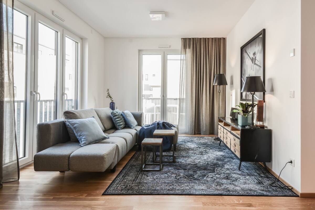 Uma sala de estar moderna com um sofá, uma mesinha, um tapete e um armário.